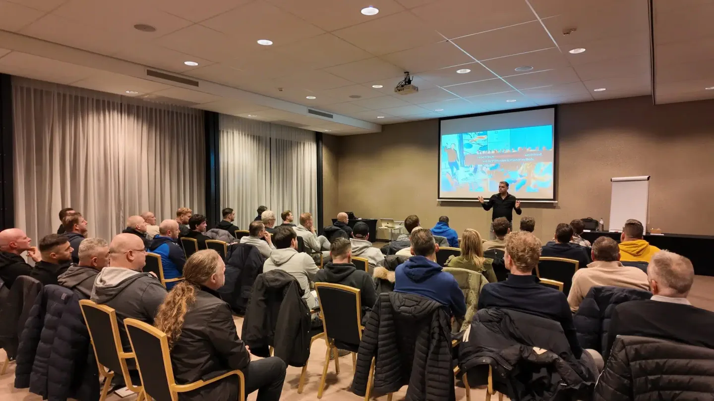 Ronnie Couwenberg, football communication expert, presenteert voor een grote groep coaches tijdens een KNVB-geaccrediteerde workshop.
