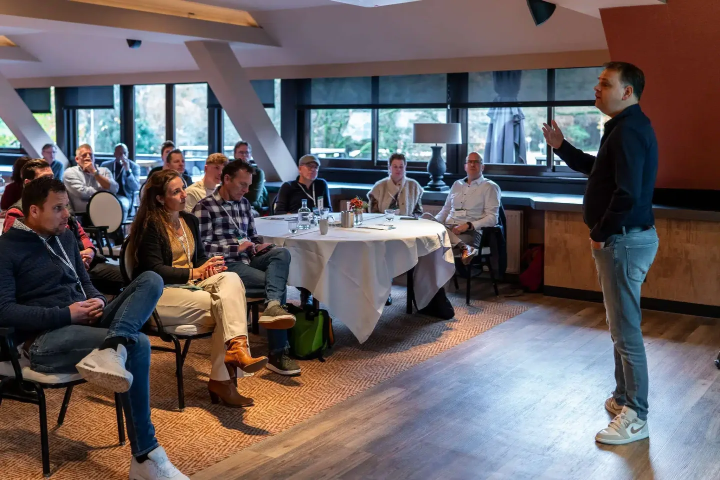 Ronnie Couwenberg presenteert voor een zittende groep leiders en teams tijdens een in-company workshop.